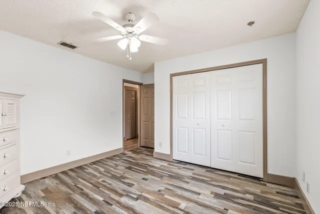 a view of an empty room with wooden floor
