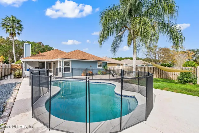 a swimming pool with table and chairs under an umbrella