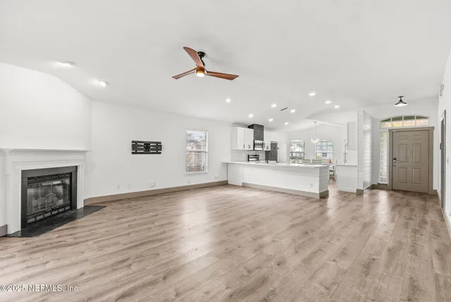 a view of an empty room with a fireplace and window