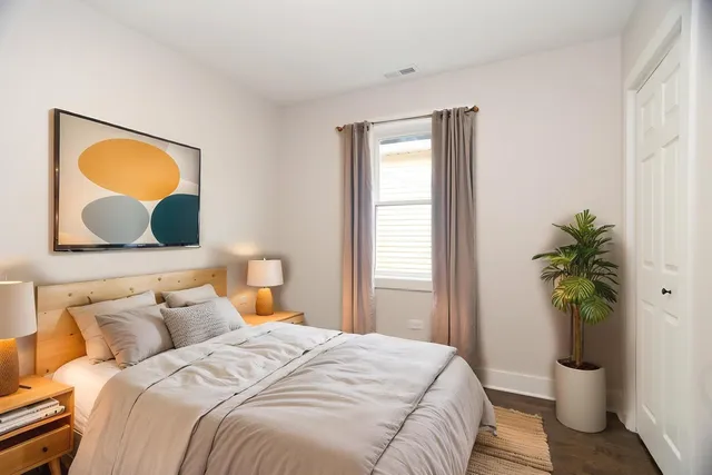 a bedroom with a bed and a potted plant
