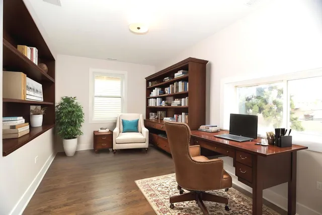 a view of a workspace with furniture and a window