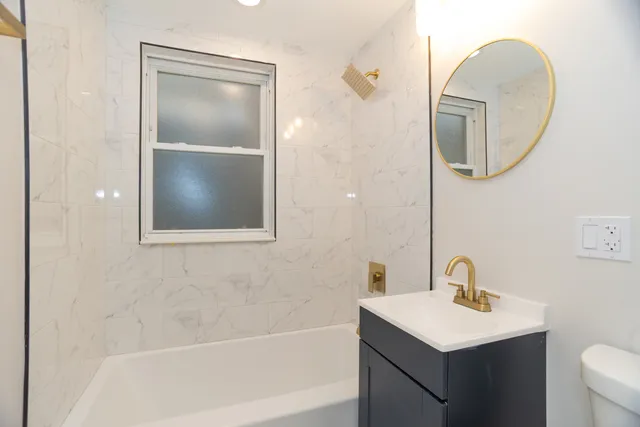 a bathroom with a toilet sink and mirror