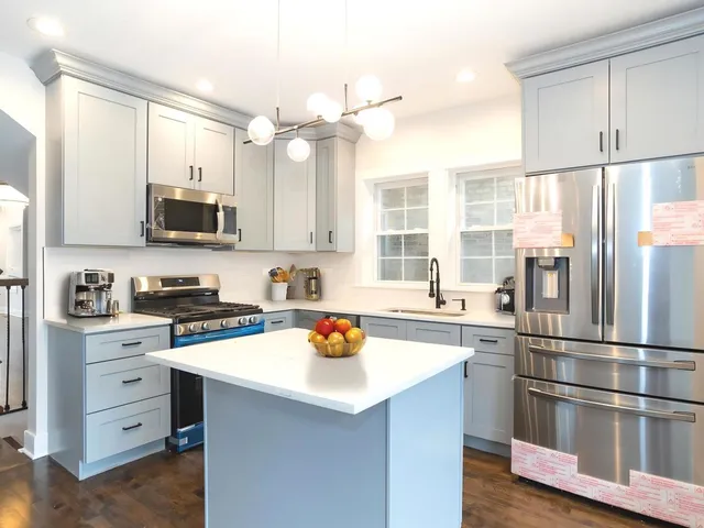 a kitchen with stainless steel appliances a stove refrigerator sink and microwave