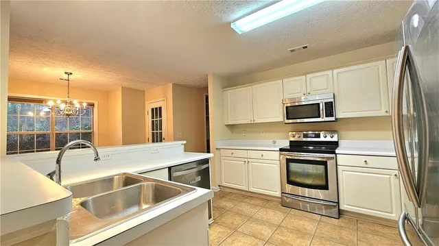 a kitchen with stainless steel appliances granite countertop a sink and a refrigerator