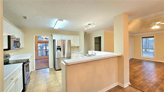 a kitchen with stainless steel appliances granite countertop a refrigerator and a stove top oven