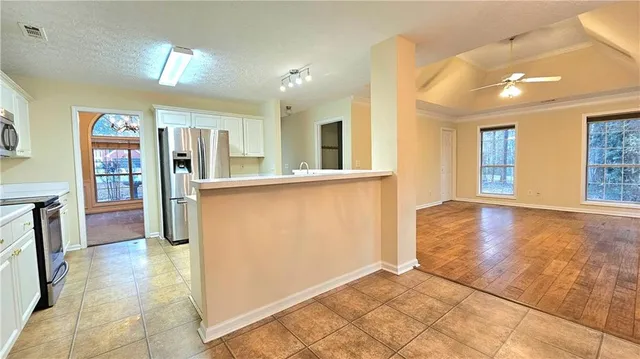 a view of a big room with wooden floor and windows