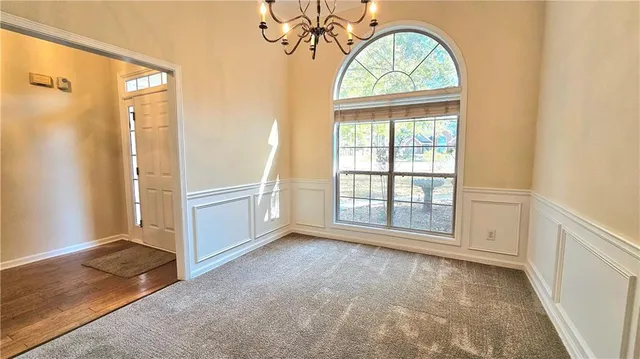 an empty room with a fireplace a rug and a large window