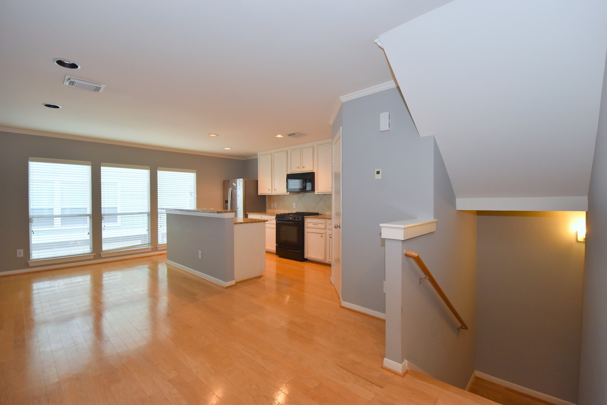1267 West 17th Street Houston, TX 77008 - Photo 10 of 22 Open-concept living space bathed in natural light, featuring gleaming hardwood floors and a seamless flow into a modern kitchen.