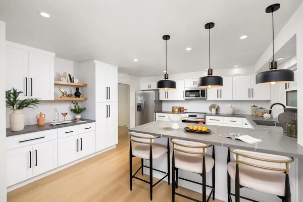 a kitchen with a sink a stove cabinets and counter space