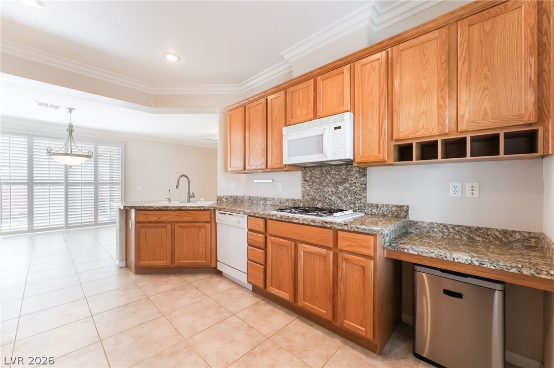 10481 Riverside Park Avenue Las Vegas, NV 89135 - Photo 14 of 51 Kitchen with white appliances, backsplash, ornamental molding, light stone countertops, and pendant lighting
