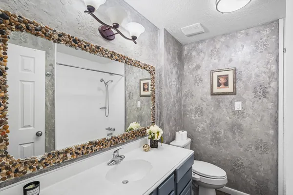 a bathroom with a sink a toilet and shower