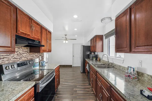 a kitchen with stainless steel appliances granite countertop a stove a sink and a microwave