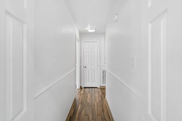 a view of a hallway with wooden floor