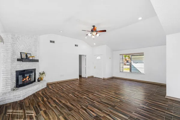 an empty room with windows and fireplace