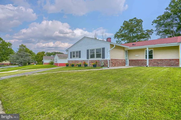 a view of an house with backyard and a tree