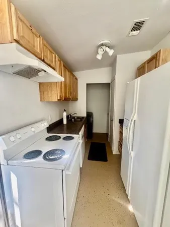 a kitchen with a refrigerator a stove top oven a sink and dishwasher