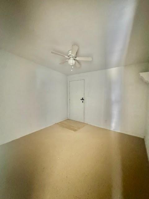 898 East Reno Road Azle, TX 76020 - Photo 4 of 6 an empty room with a chandelier fan and windows