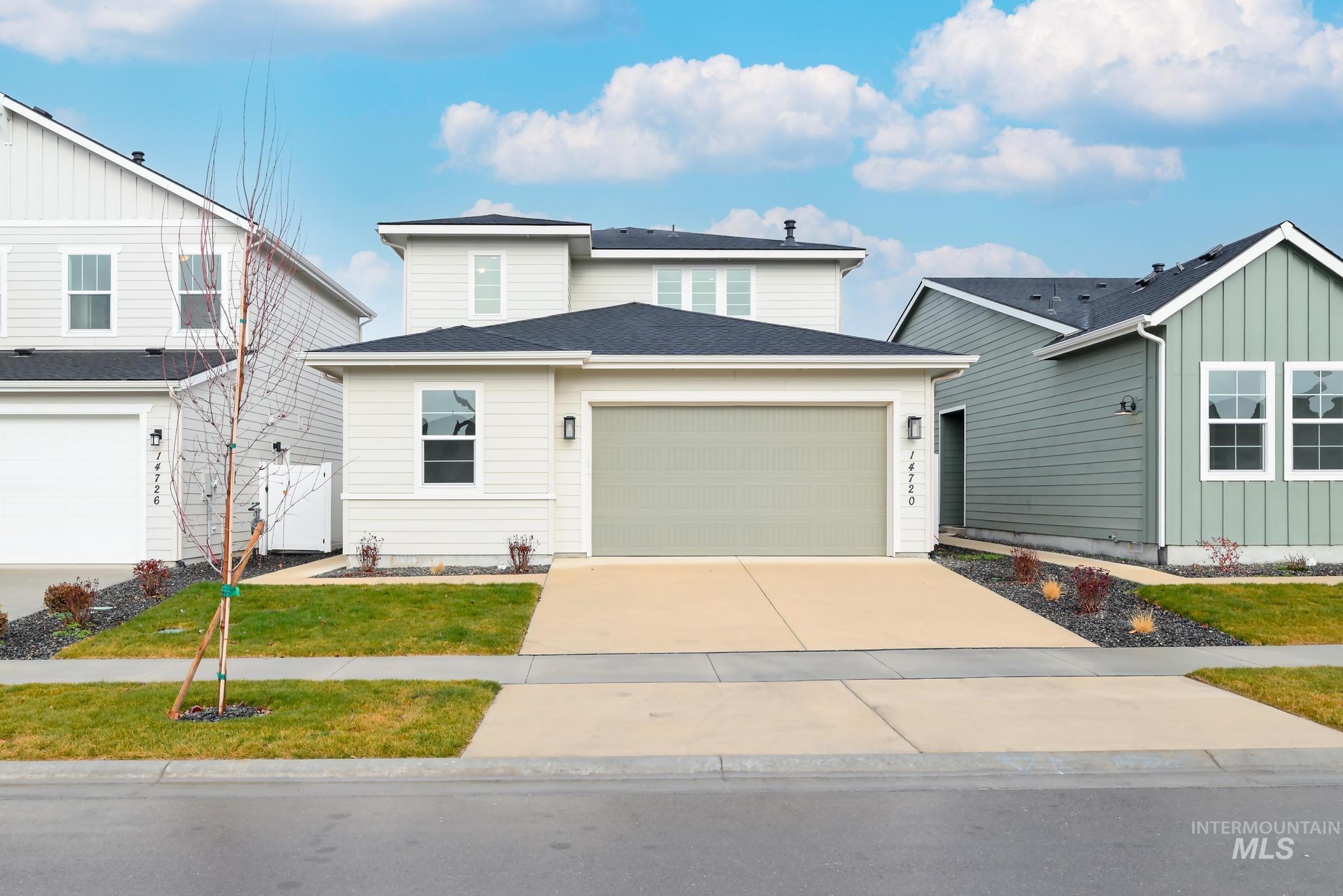 View of front of home with driveway, roof with shingles, and a garage