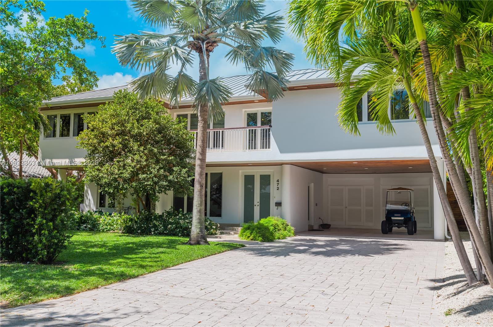 472 Warren Lane Key Biscayne, FL 33149 - Photo 3 of 39 a front view of a house with a garden and trees