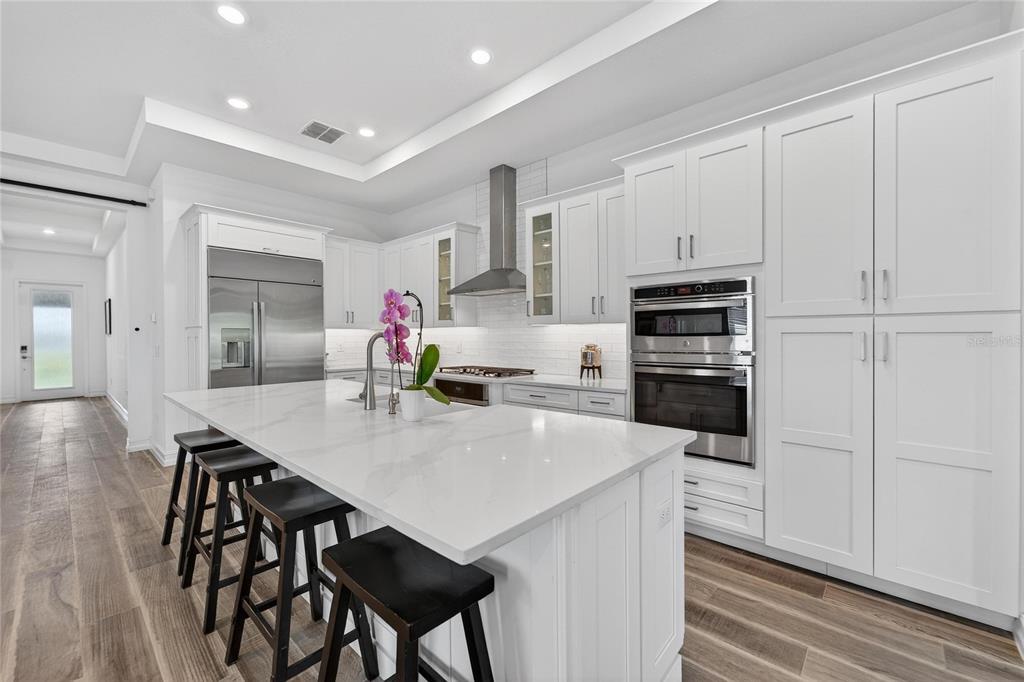 1071 Seagrape Drive Ruskin, FL 33570 - Photo 10 of 100 a kitchen with stainless steel appliances kitchen island a table chairs and a refrigerator