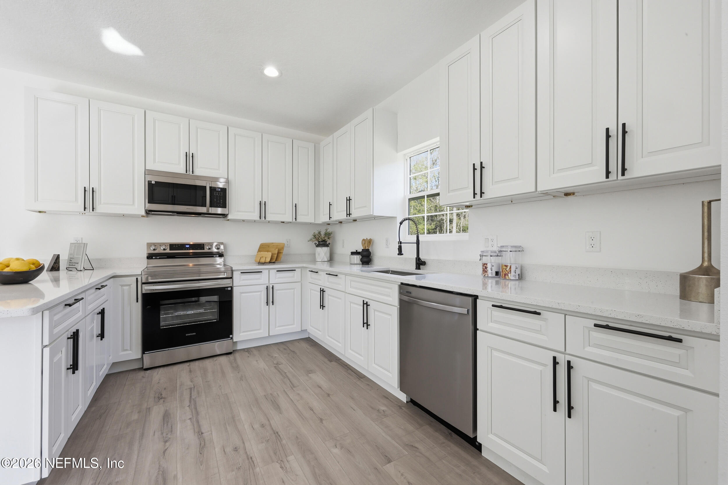 4199 Pine Road Orange Park, FL 32065 - Photo 16 of 44 a kitchen with granite countertop white cabinets and stainless steel appliances