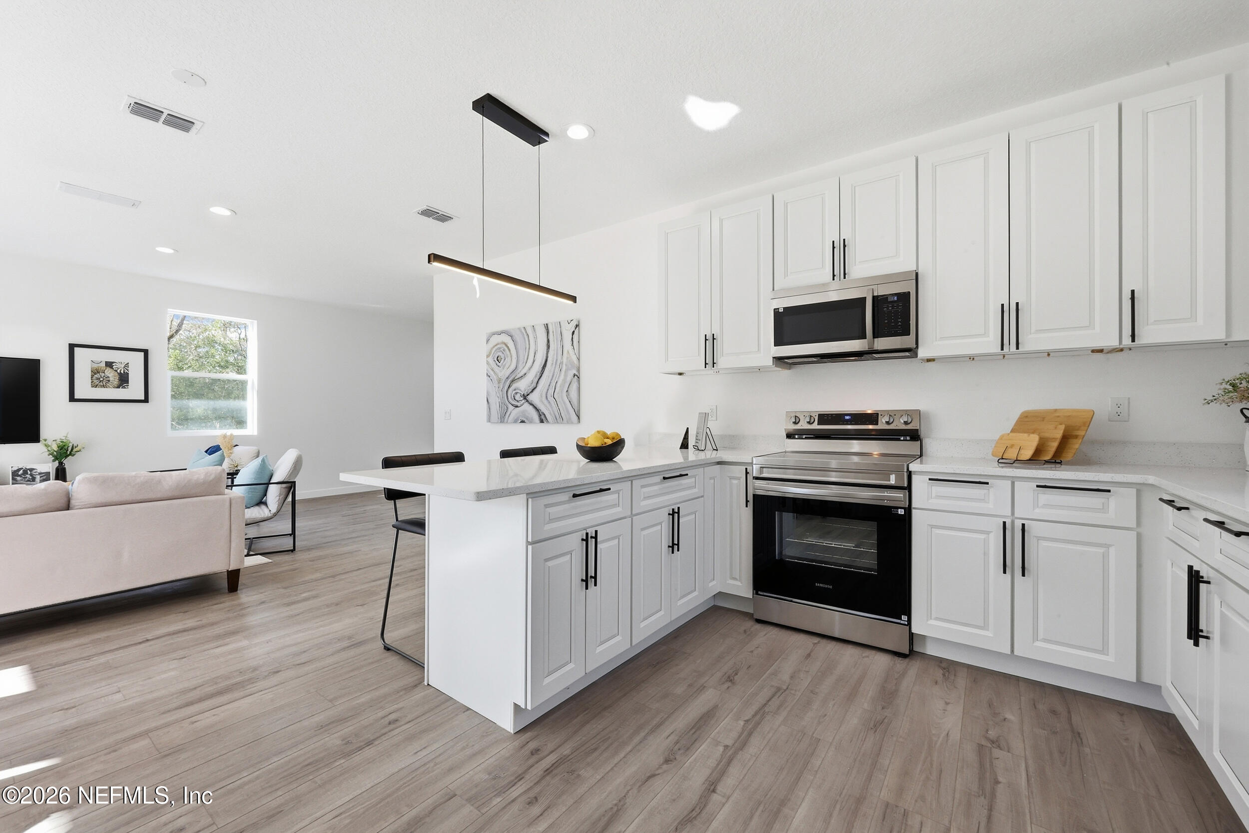 4199 Pine Road Orange Park, FL 32065 - Photo 17 of 44 a kitchen with stainless steel appliances a white stove top oven a sink dishwasher and a refrigerator with wooden floor