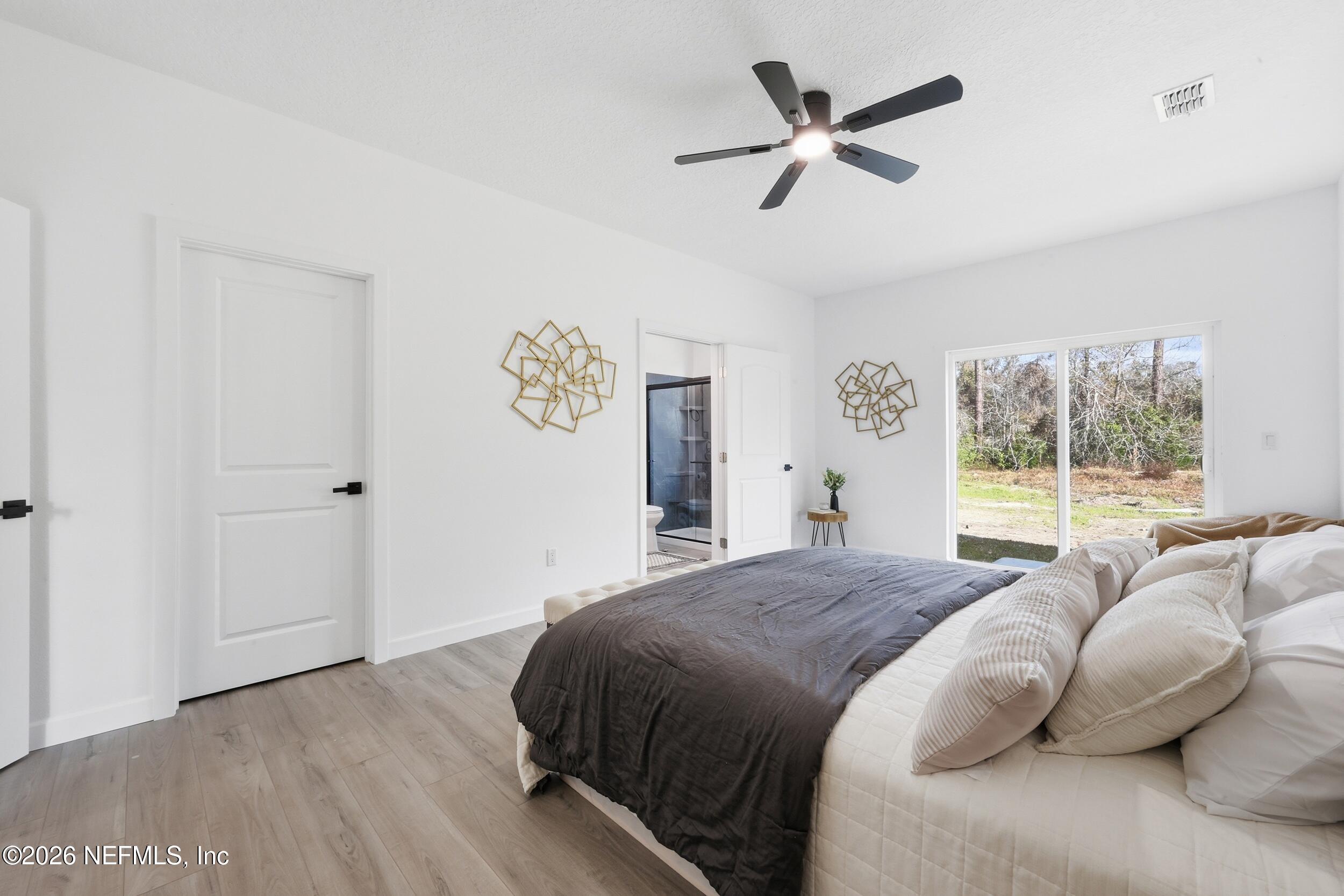 4199 Pine Road Orange Park, FL 32065 - Photo 22 of 44 a spacious bedroom with a bed and a large window with the outer view