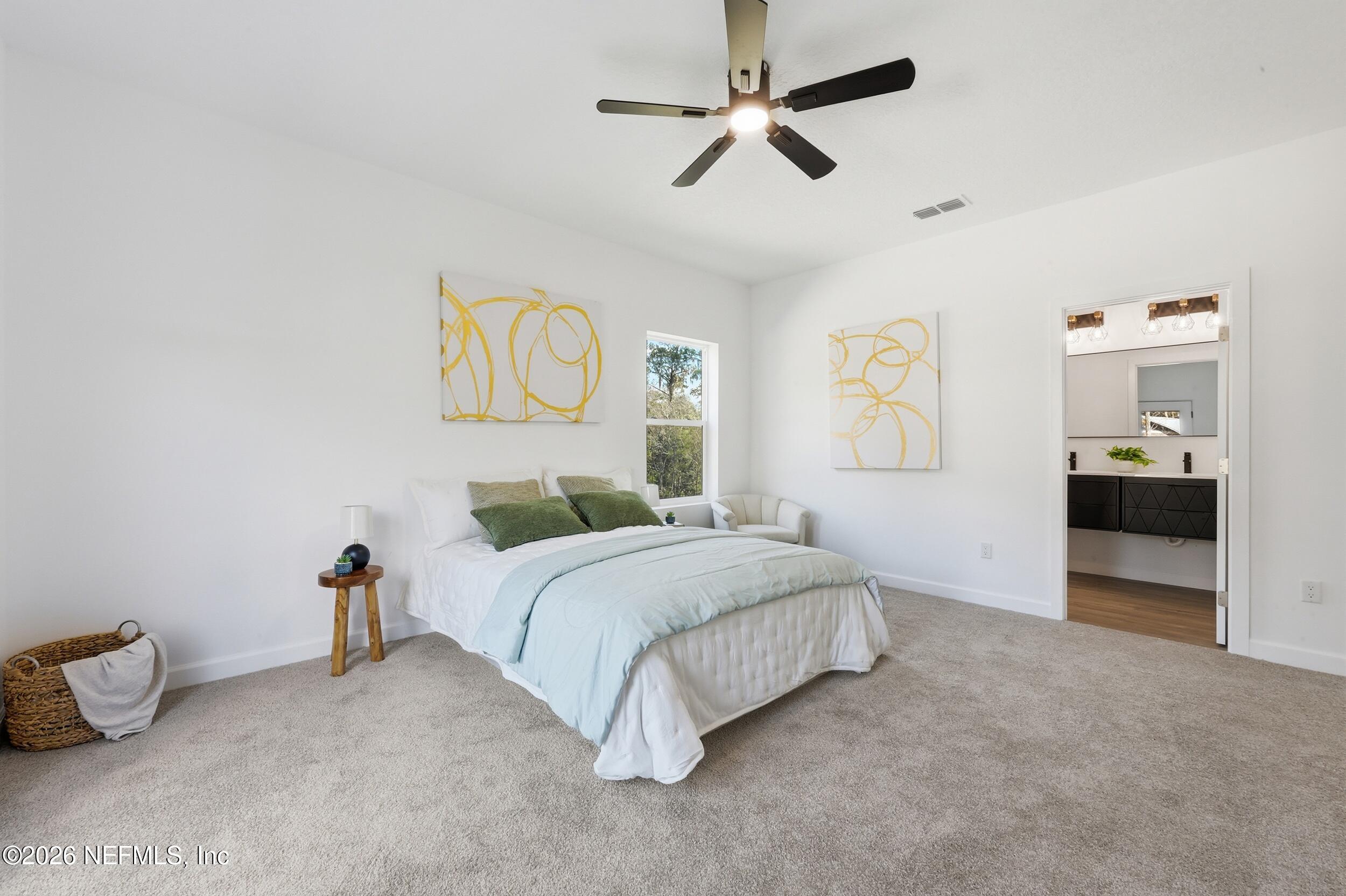 4199 Pine Road Orange Park, FL 32065 - Photo 30 of 44 a spacious bedroom with a bed and a chandelier
