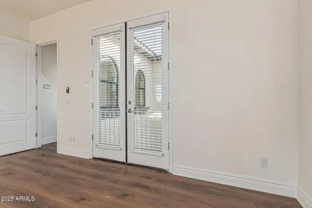 an empty room with wooden floor windows and outdoor