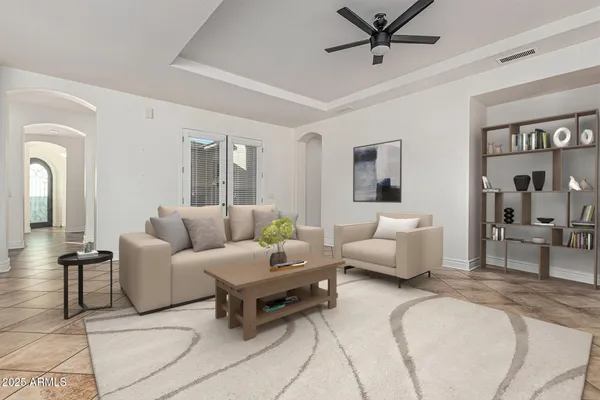 a spacious bedroom with a bed a couch and potted plants on the dresser