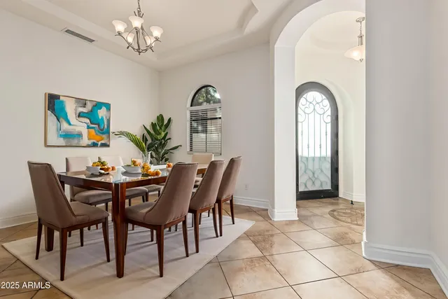 a kitchen with kitchen island a dining table chairs stainless steel appliances and cabinets