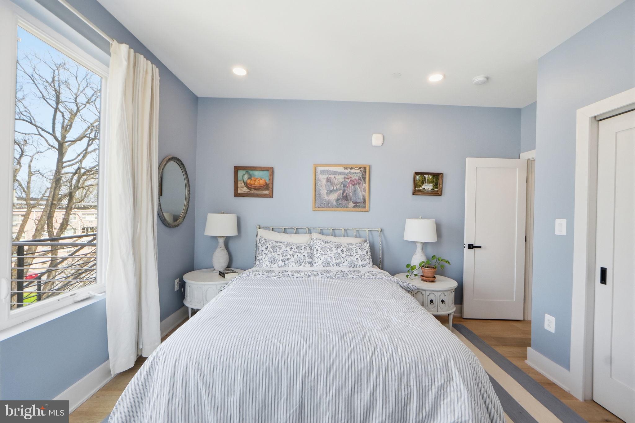623 Kennedy Street Northwest, Unit 10 Washington, DC 20011 - Photo 16 of 34 a bedroom with a large bed and a chandelier