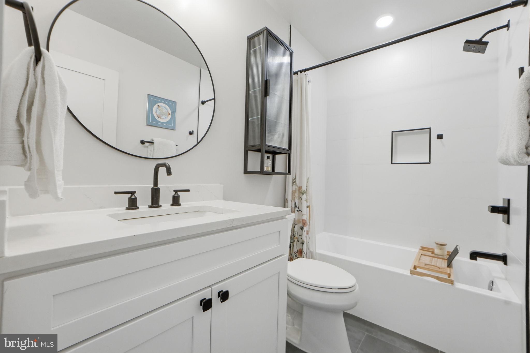 623 Kennedy Street Northwest, Unit 10 Washington, DC 20011 - Photo 17 of 34 a bathroom with a sink a toilet and a mirror
