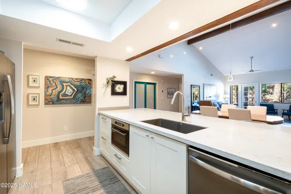 a kitchen with stainless steel appliances granite countertop a sink and dishwasher with white cabinets