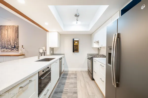 a kitchen with stainless steel appliances granite countertop a sink stove and refrigerator