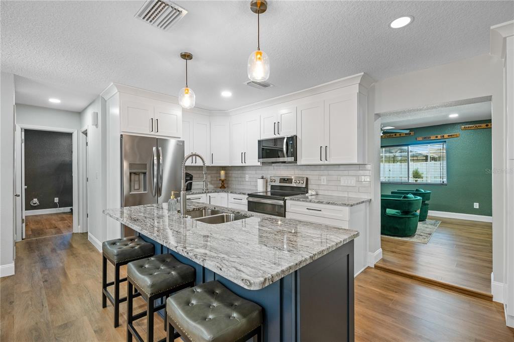 9653 Golden Grove Street Seminole, FL 33772 - Photo 3 of 29 a kitchen with stainless steel appliances granite countertop a stove refrigerator and cabinets