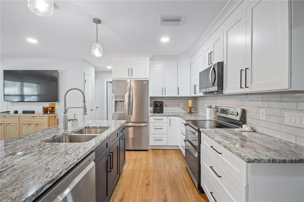 9653 Golden Grove Street Seminole, FL 33772 - Photo 4 of 29 a kitchen with granite countertop white cabinets and stainless steel appliances