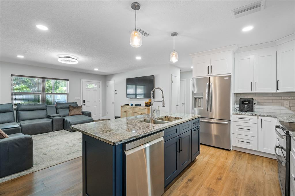 9653 Golden Grove Street Seminole, FL 33772 - Photo 5 of 29 a kitchen with stainless steel appliances granite countertop a kitchen island a stove and a sink
