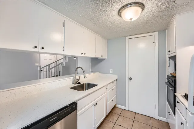 a kitchen with a sink a stove and cabinets