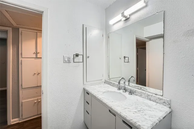 a bathroom with a granite countertop sink and a mirror
