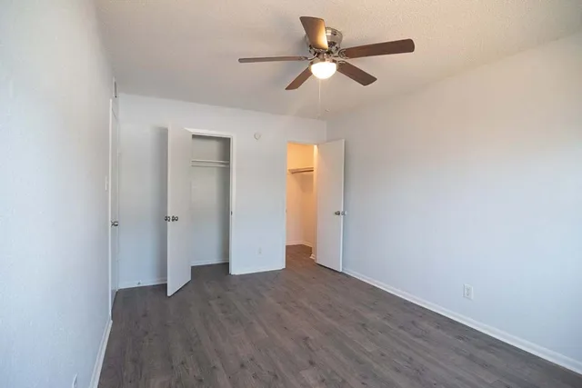 a view of a big room with wooden floor and windows