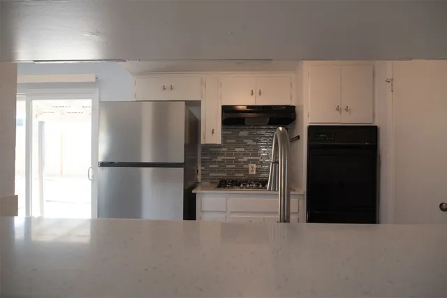 a kitchen with stainless steel appliances a refrigerator and a stove