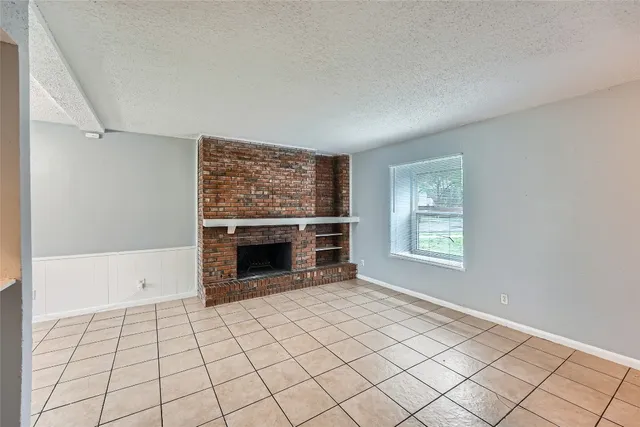a view of an empty room with a fireplace and a window
