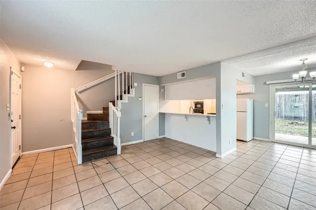 a view of empty room with wooden cabinet and refrigerator