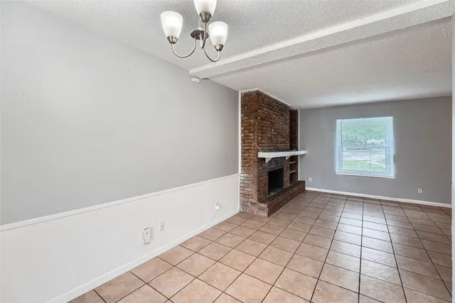 an empty room with windows and fireplace