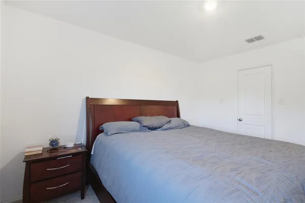 a bedroom with a bed and a night stand