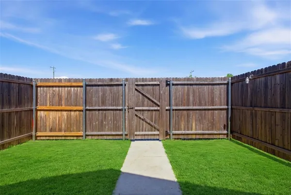 a view of a yard with wooden fence