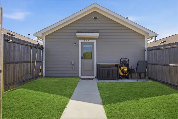 a front view of a house with garden and a wooden fence