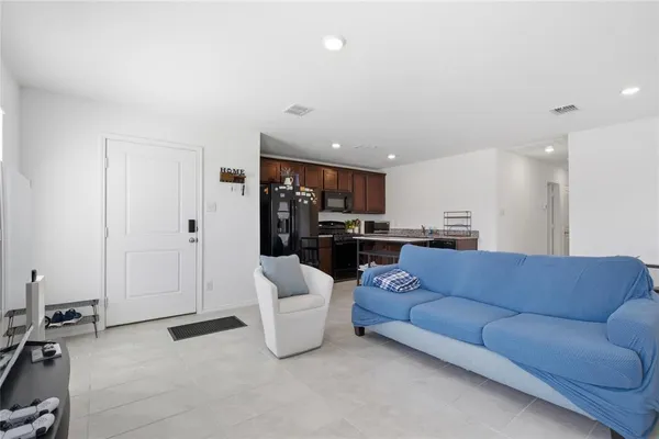 a living room with furniture and kitchen view