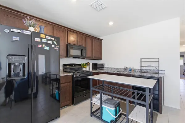 a kitchen with stainless steel appliances a stove refrigerator sink and cabinets